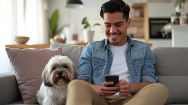 Joven viendo una aplicacion en su celular con su perro